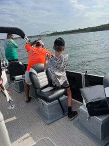 Family enjoying a spring 2025 striper fishing trip with a guide on Lake Texoma